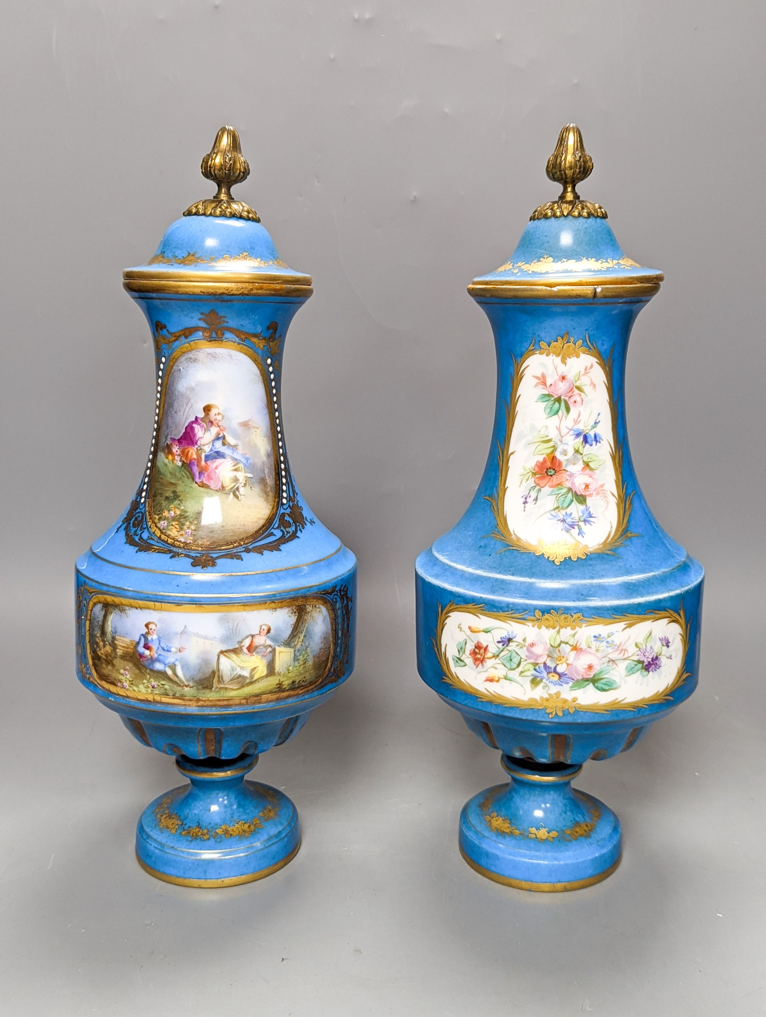 A pair of Sevres style porcelain bleu celeste ground vases and covers, 34cm